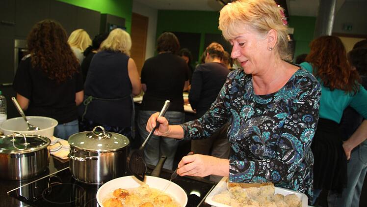 Sylvia Krug hat die Aufgabe, die Kartoffel-Hackfleisch-Bällchen ins heiße Fett zu geben - und zu frittieren.