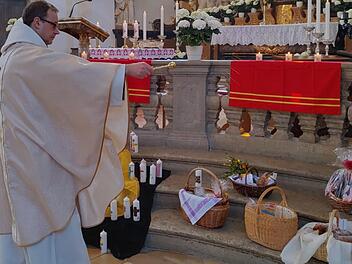 In einer fast menschenleeren Basilika Gößweinstein segnet Pfarrer  Pater Ludwig Mazur während des Oster-Festgottesdienstes die Osterspeisen vor  dem Altar.  Foto: Thomas Weichert