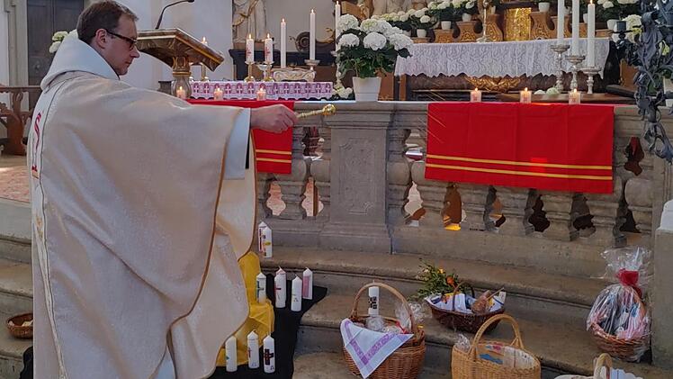 In einer fast menschenleeren Basilika Gößweinstein segnet Pfarrer  Pater Ludwig Mazur während des Oster-Festgottesdienstes die Osterspeisen vor  dem Altar.  Foto: Thomas Weichert