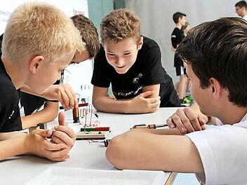 Timo Gebhardt erklärt Luis, Tom und Nikolai, wie ein Elektromotor funktioniert. Fotos: Daniela Pondelicek