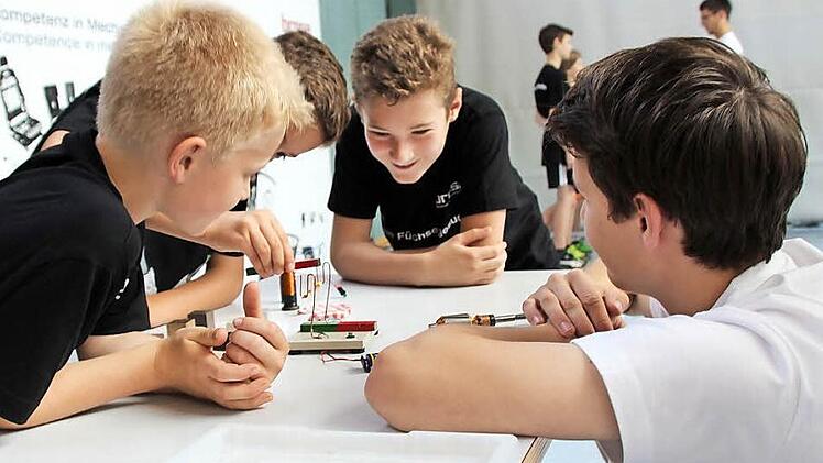 Timo Gebhardt erklärt Luis, Tom und Nikolai, wie ein Elektromotor funktioniert. Fotos: Daniela Pondelicek