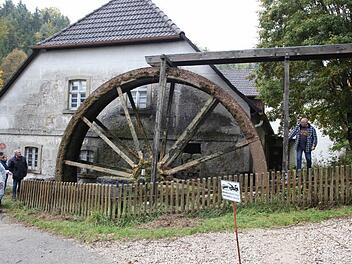 Die neuen Besitzer freuen sich mit Bürgermeister Helmut Krämer, dass das Mühlrad wieder in Betrieb ist. Foto: Georg Wolf
