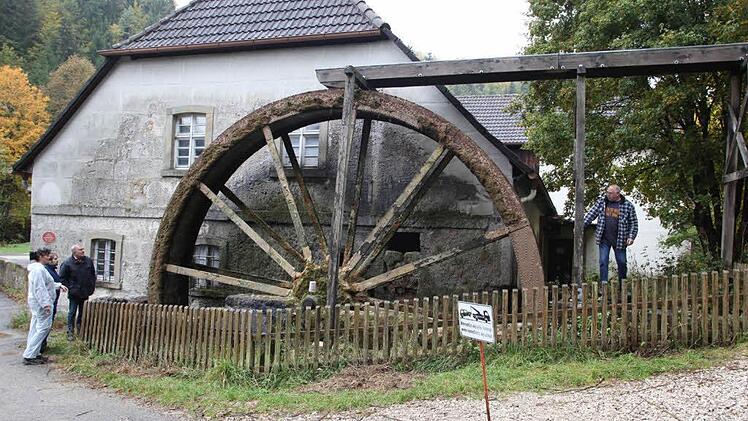 Die neuen Besitzer freuen sich mit Bürgermeister Helmut Krämer, dass das Mühlrad wieder in Betrieb ist. Foto: Georg Wolf