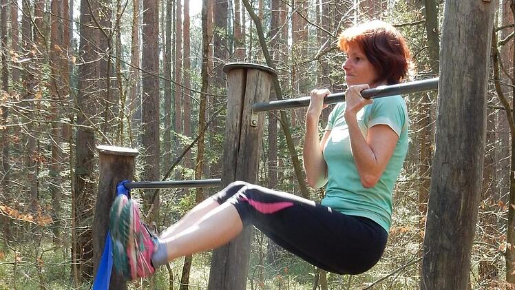 Annemarie Schabbehard hält sich im Hauptsmoorwald fit, hier bei Klimmzügen.