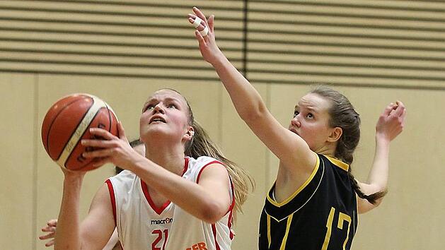 Die Bambergerin Magdalena Landwehr l&auml;sst sich weder von gleich zwei Gegenspielerinnen - Frederike Scherer (verdeckt) und Franziska Wagner (r.) - noch von einem Foul in ihrem Drang zum Korb bremsen und schlie&szlig;t erneut erfolgreich ab. 29 Punkte waren ihre stolze Ausbeute. Foto: sportpress