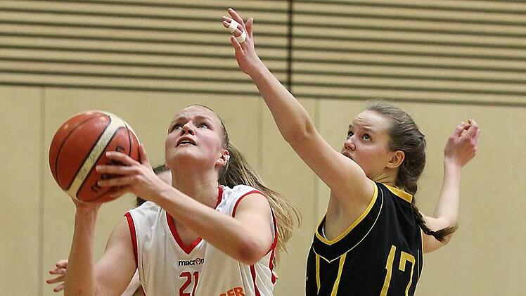 Die Bambergerin Magdalena Landwehr lässt sich weder von gleich zwei Gegenspielerinnen - Frederike Scherer (verdeckt) und Franziska Wagner (r.) - noch von einem Foul in ihrem Drang zum Korb bremsen und schließt erneut erfolgreich ab. 29 Punkte waren ihre stolze Ausbeute. Foto: sportpress