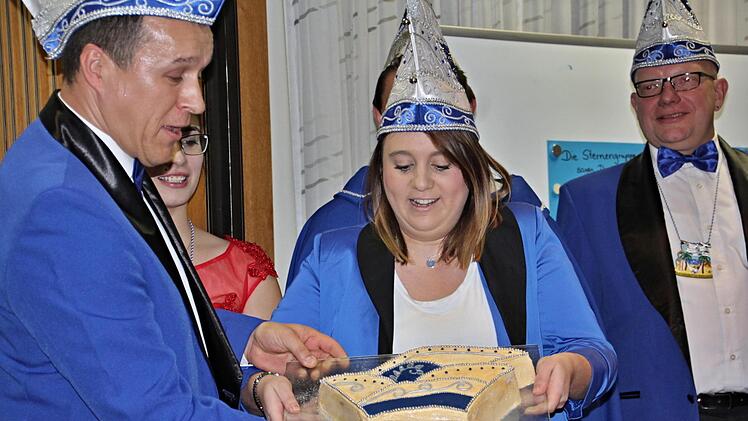 Ein "Narrenkappenkuchen" für Sarah Schmidtlein einziges weibliches Mitglied im Sechserrat in Rentweinsdorf, von Oliver Stark (links),. Foto: Helmut Will