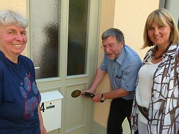 Im Beisein von Renate Schillig (links) und der Zweiten Bürgermeisterin Birgit Weber (rechts) nimmt Hans-Heinrich Eidt einen Akuschrauber in die Hand und befestigt die Medaille.  Foto: Lothar Weidner