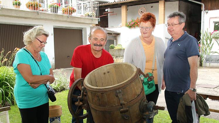 Hartmut Reißenweber (Mitte) zeigte den Besuchern die Funktion einer alten Waschmaschine aus Holz. Foto: Michael Stelzner