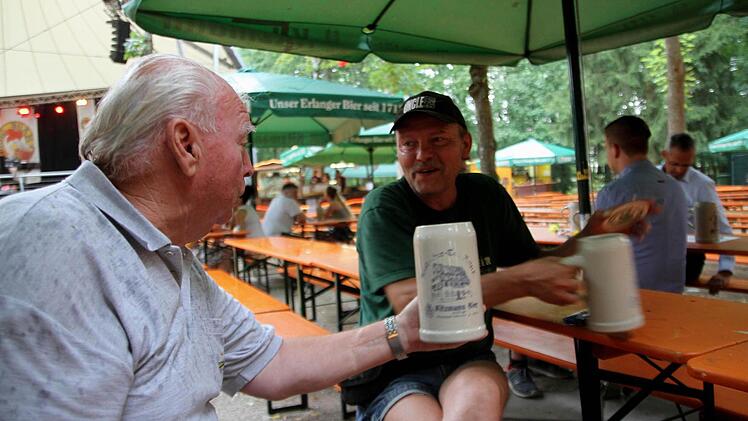 Rudi Lochner (links) zog eine Maß unter dem Schirm dem Heimweg im Regen vor. Foto: Richard Sänger