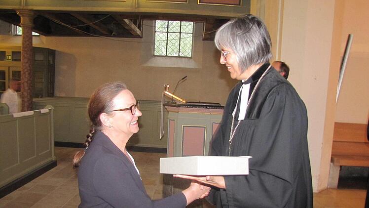 Petra Heeb nimmt aus der Hand von Regionalbischöfin Dr. Dorothea Greiner die neue Altarbibel für die St.-Lukas-Kirche am Ketschendorfer Hang entgegen. Foto: Martin Koch