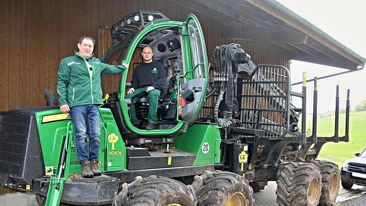 Daniel Ebert im Führerhaus des John-Deere-Rückezuges und (links) Chef Georg Ebert. Das Gefährt ist eine hochtechnisierte Maschine, die mit einem kleinen Knopf gelenkt wird.Helmut Will