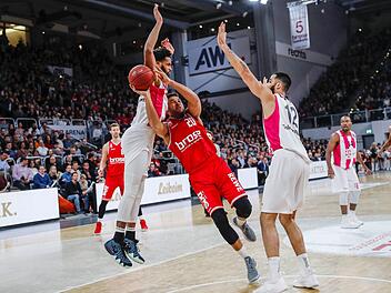 Nach dem Bundesligaspiel am 16. Dezember kommen die Telekom Baskets Bonn am 20. Januar wieder in die Brose-Arena. Im Pokal-Halbfinale   wollen sie sich für die 70:77-Niederlage revanchieren. Hier bedrängen die Bonner James Webb (links) und Martin Breunig (rechts) den Bamberger Elias Harris. Foto: Daniel Löb