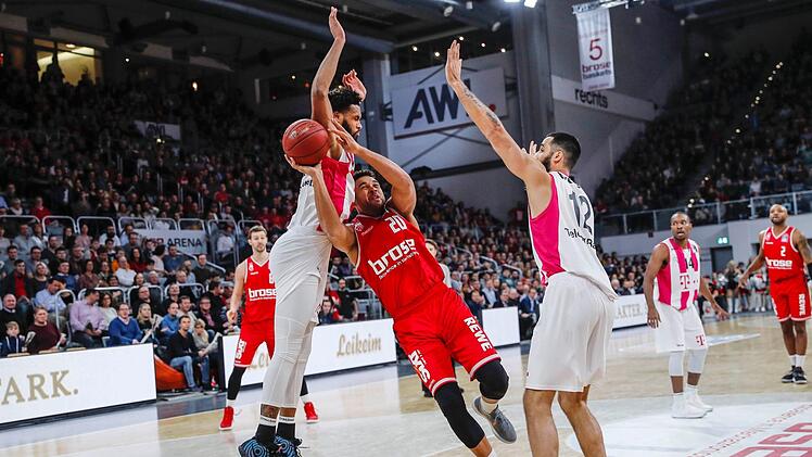 Nach dem Bundesligaspiel am 16. Dezember kommen die Telekom Baskets Bonn am 20. Januar wieder in die Brose-Arena. Im Pokal-Halbfinale   wollen sie sich für die 70:77-Niederlage revanchieren. Hier bedrängen die Bonner James Webb (links) und Martin Breunig (rechts) den Bamberger Elias Harris. Foto: Daniel Löb