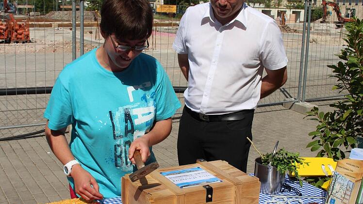Nadja Dölfel schlägt einen Nagel in die Kiste, Detlev Troll schaut zu.