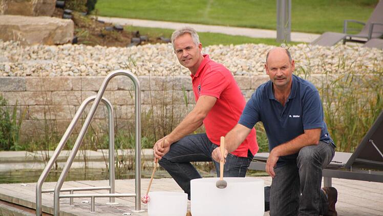 Die Saunameister Peter Diller (links) und Roland Müller bereiten gemeinsam mit vielen anderen das "Sauna-Opening" vor. Die beiden wirken bei den "Aqua-Soleros" mit, die ein Musical für diesen Abend zusammengestellt haben. Hier proben sie gerade mit den Klangschalen aus Kristall, die auf der "Bühne" am neuen Badesee erklingen werden. Foto: Matthias Einwag