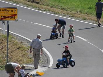 Freie Fahrt für die Kinder: Diese durften die Ortsdurchfahrt mit ihren Fahrzeugen als erste auf die Probe stellen. Bei einer Feier wurde die Straße dann für den motorisierten Verkehr freigegeben. Fotos: Helmut Will