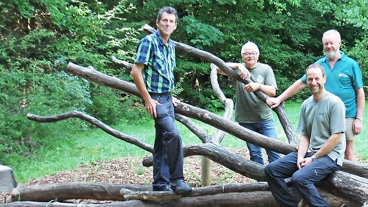 Ein Kletterstamm aus Eichenholz ist die neue Attraktion f&uuml;r Kinder am Wei&szlig;fichtensee. Winfried Seufert (von links) und Norbert Schmucker vom Naturpark Ha&szlig;berge dankten Sven Kaps, dem Revierleiter der Bayerischen Staatsforsten, f&uuml;r die Bereitstellung des Stammes. Mit auf dem Foto Wolfgang Kettler von den Bayerischen Staatsforsten.  Foto: Naturpark Ha&szlig;berge