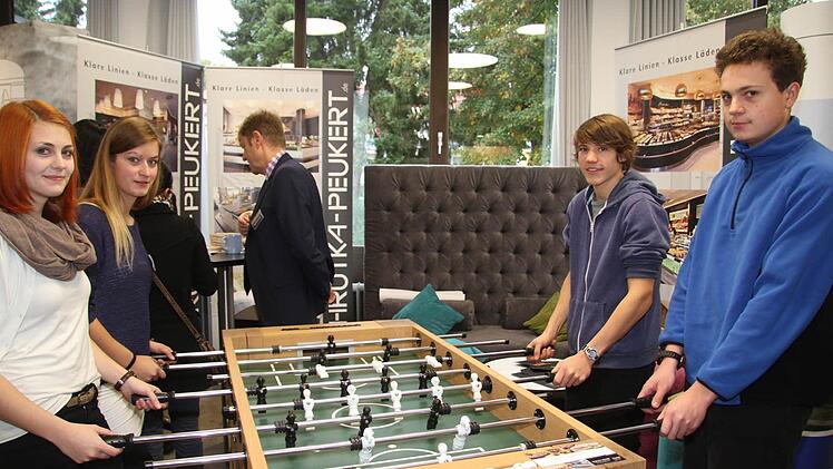 Am Kicker der Firma Schrutka-Peukert wird nicht einfach nur gespielt: Franziska Wirsing (18) und Kim Hörath (21) erzählen den beiden Jungs, was man als technischer Produktdesigner so alles macht - und Florian Konrad (18) und Gabriel Moser (16) hören gespannt zu.