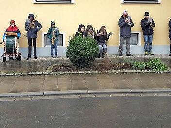 Eine der drei Musikgruppen der Musikvereinigung Ebensfeld flüchtete sich am Silvestertag bei Dauerregen unter die schützenden Dachvorsprünge eines Hauses. Kurz darauf brachen die Musiker das Spiel ab, weil sonst die hölzernen Instrumente beschädigt worden wären. Foto: Otto Weidner