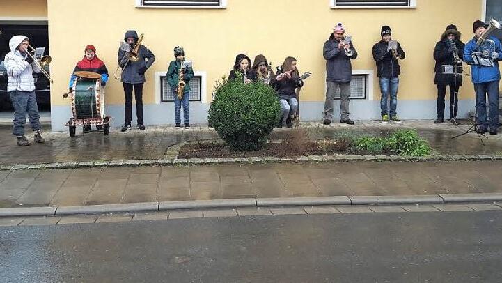 Eine der drei Musikgruppen der Musikvereinigung Ebensfeld flüchtete sich am Silvestertag bei Dauerregen unter die schützenden Dachvorsprünge eines Hauses. Kurz darauf brachen die Musiker das Spiel ab, weil sonst die hölzernen Instrumente beschädigt worden wären. Foto: Otto Weidner