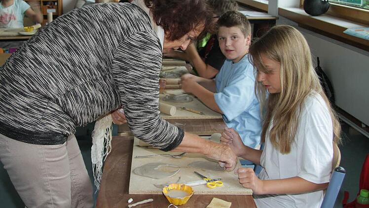 Schulleiterin Anne Greim unterstützt im Unterricht das Töpferprojekt und fertigt mit den Schülern Wandtafeln.