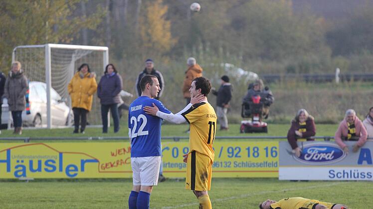 Ein Foto wie ein Gem&auml;lde: Trailsdorfs Christoph Heumann (blaues Trikot) und sein Th&uuml;ngfelder Gegen&uuml;ber David Schuster waren Teil eines Fu&szlig;ball-Spektakels in der A-Klasse 3, das alle Beteiligten aus den Socken gehauen hat - insbesondere den v&ouml;llig ersch&ouml;pften Kapit&auml;n Felix Bauer (r.). Im Topspiel erzielte Th&uuml;ngfeld in der Nachspielzeit  noch den Treffer zum 7:7-Endstand. Foto: Markus Sch&uuml;tz/anpfiff.info
