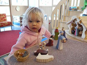 Die zweijährige Freya schaut sich die Figuren aus der Weihnachtskrippe ganz genau an. Die Holzfiguren im Montessori-Kinderhaus gefallen ihr.   Fotos: Pauline Lindner