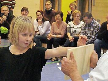 Voll konzentriert ist Hannah Unglaub bereit, das Holzbrett durchzuschlagen. Mit im Bild (rechts) Kursleiter Fred Busse. Foto: Schule