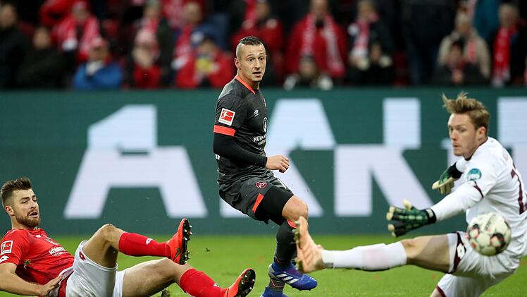 Ein Tor, das keines sein durfte: Adam Zrelak (Mitte) war um eine Fu&szlig;spitze im Abseits, bevor er den Ball am Mainzer Torwart Florian M&uuml;ller in den Kasten lenkte. Es w&auml;re keine klare Fehlentscheidung gewesen, wenn der Treffer gez&auml;hlt h&auml;tte, aber der Videoassistent griff trotzdem ein. Foto: Heiko Becker