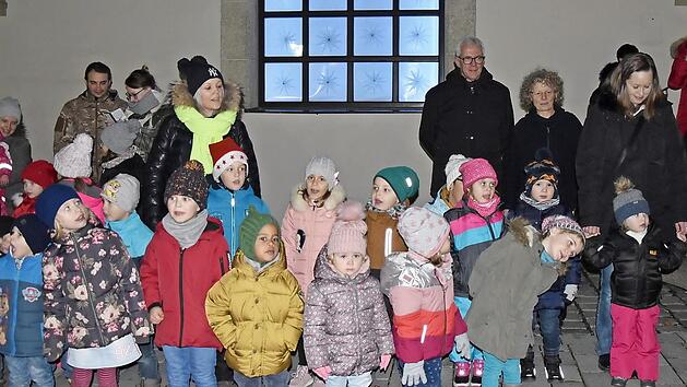 Das erste Fenster des begehbaren Adventskalenders wurde am Sonntag an der Stadthalle in Ha&szlig;furt ge&ouml;ffnet. Die Kinder des st&auml;dtischen Kindergartens sangen unter anderem von Keksm&auml;usen.  Foto: Christiane Reuther