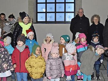 Das erste Fenster des begehbaren Adventskalenders wurde am Sonntag an der Stadthalle in Haßfurt geöffnet. Die Kinder des städtischen Kindergartens sangen unter anderem von Keksmäusen.  Foto: Christiane Reuther