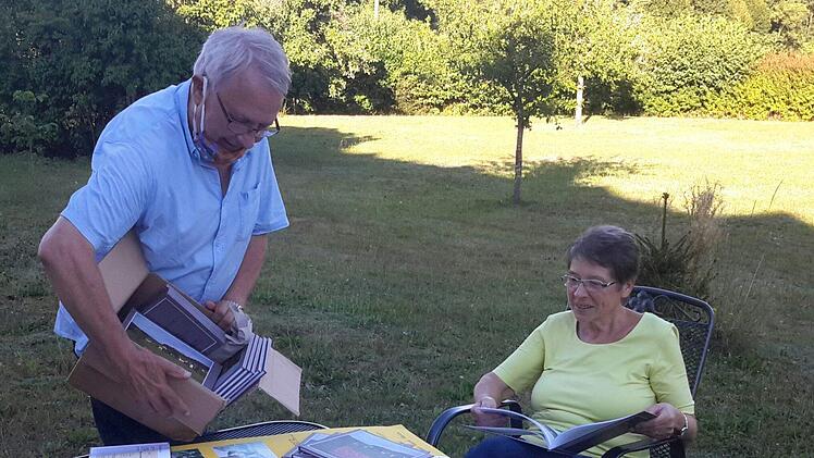 Den ersten Karton mit den noch druckfrischen Büchern packt der evangelische Pfarrer Gerd Kirchner  aus. Erika Hänlein  nimmt auf dem Sonnenhof in Eckarts gleich einmal ein Exemplar unter die Lupe. Sie bildet zusammen mit dem Geistlichen und ihrem Sohn Markus das Autorentrio. Foto: Rolf Pralle