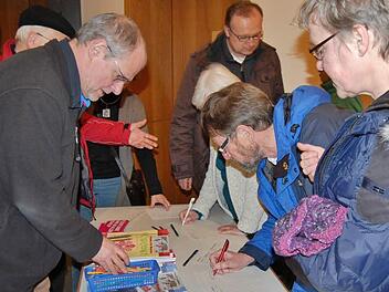 Augustiner-Pater Markus Reis (links) mit interessierten Helfern beim Eintrag in die Gruppenlisten. Foto: Sigismund von Dobschütz