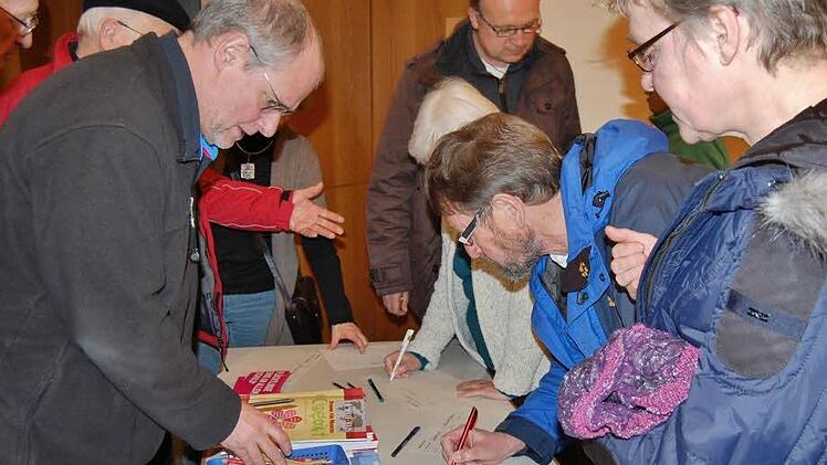 Augustiner-Pater Markus Reis (links) mit interessierten Helfern beim Eintrag in die Gruppenlisten. Foto: Sigismund von Dobschütz