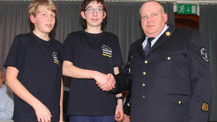 Kommandant Heinrich Poperl reicht den letzten verbleibenden Jugendlichen die Hand: Nur noch Jacob Hartmann und Willi Dippold gehören der Jugendwehr an. Deshalb will die Feuerwehr eine Nachwuchskampagne starten.
