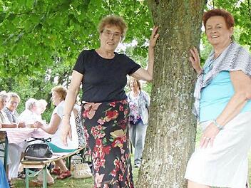 Gerda Sinnig und eine ihrer Freundinnen von damals, Edeltraud Günther, staunen, wie groß "ihre" Linde geworden ist. Im Hintergrund wird kräftig gefeiert.  Foto: Katharina Müller-Sanke