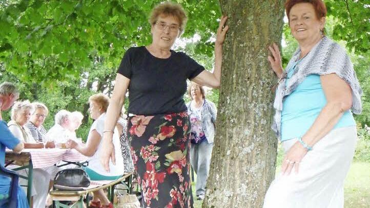 Gerda Sinnig und eine ihrer Freundinnen von damals, Edeltraud Günther, staunen, wie groß "ihre" Linde geworden ist. Im Hintergrund wird kräftig gefeiert.  Foto: Katharina Müller-Sanke