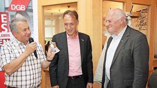 Ein Geschenk f&uuml;r den Gast: DGB-Kreisvorsitzender Heinz G&auml;rtner (links) schenkte Fritz Sch&ouml;sser f&uuml;r seinen gelungenen Vortrag eine Korbmacherin aus Porzellan. Dar&uuml;ber freute sich auch Mathias Eckardt, Gesch&auml;ftsf&uuml;hrer der DGB-Region Oberfranken.