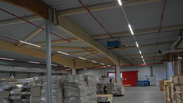 Den erneuerten Teil der Lagerhalle erkennt man an den hellen Leimbindern in der Dachkonstruktion.