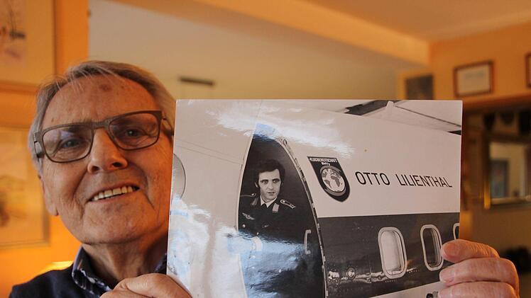 Herbert Mengesdorf hält ein Foto in der Hand, das ihn als jungen Mann an der Flugzeugtür der "Otto Lilienthal" zeigt. Fuchs