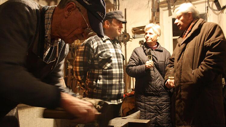 Willi Gruschke bearbeitet das glühende Eisen, während Heinz Zippelius im Hintergrund die Geschichte des Elfleinshäusles erläutert. Fotos: Riegler