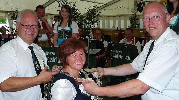 Kommissar Stefan Sigmund (links) und 1. Schützenmeister Frank Wunner (rechts) legen Beate Sigmund (Bildmitte) die Königkette an. Fotos: Klaus-Peter Wulf