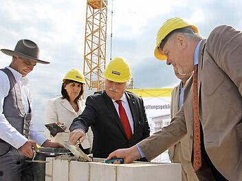 Polier Jürgen Dorst passt auf, dass die Grundsteinlegung mit Kelle gelingt (von links): Tina-Maria Vlantoussi-Kaeser, Thomas Kaeser und OB Norbert Tessmer. Foto: Christiane Lehmann