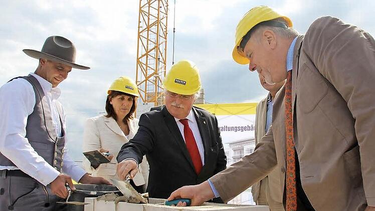 Polier Jürgen Dorst passt auf, dass die Grundsteinlegung mit Kelle gelingt (von links): Tina-Maria Vlantoussi-Kaeser, Thomas Kaeser und OB Norbert Tessmer. Foto: Christiane Lehmann