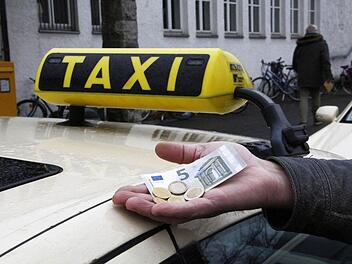Ein Taxifahrer zeigt, welcher Stundenlohn ihm künftig zusteht. Foto: Peter Groscurth