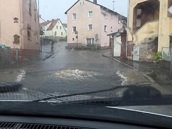 So erlebte Jacqueline Keßler das Unwetter in Wollbach: Mehrere Kanaldeckel in der Rhönstraße hatte es angehoben, aus dem Kanal sprudelt das Wasser auf die Straßen. Gleich in mehreren Straßen standen Keller unter Wasser. Foto: Archiv/Jacqueline Keßler
