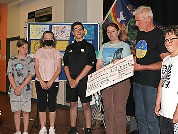 Tom Sauer bekam bei einer Veranstaltung in der Aula der Siegmund-Loewe-Schule 1630 Euro f&uuml;r die &bdquo;Aktion Roman&ldquo; &uuml;berreicht (v. l.): Anna Gratz, Noah Hauck, Sarah Schindler, Felix Gold, Celina Bracki-Emmerling, Tom Sauer, Lukas Schindler und Nils Hohenadel.