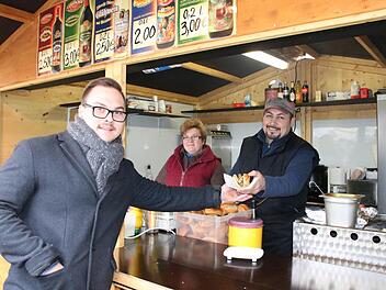 Raphael Zehe (von links) besuchte gestern trotz des Anschlags in Berlin den Bad Kissinger Weihnachtsmarkt und kaufte eine Wurst bei Elena und Spartak Badikjan. Foto: Ralf Ruppert