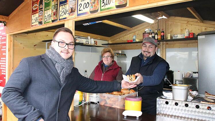 Raphael Zehe (von links) besuchte gestern trotz des Anschlags in Berlin den Bad Kissinger Weihnachtsmarkt und kaufte eine Wurst bei Elena und Spartak Badikjan. Foto: Ralf Ruppert